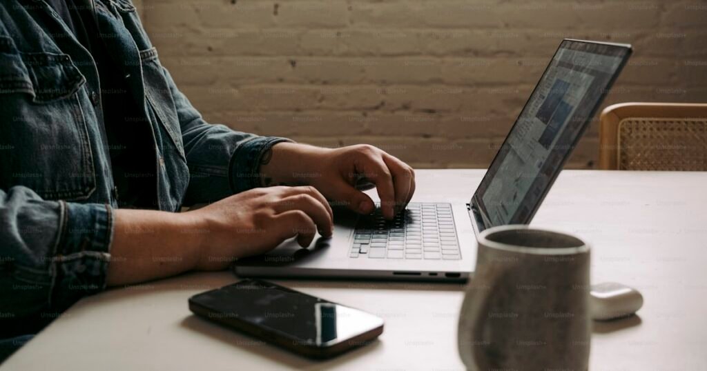 Small business owner writing on laptop